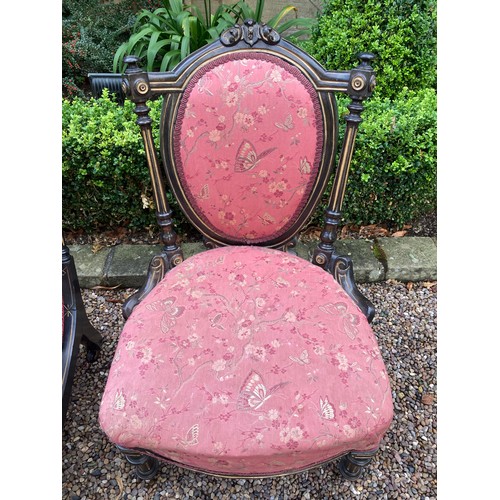 780 - Two Victorian ebonised and gilt upholstered nursing chairs both with turn front legs ans castors.