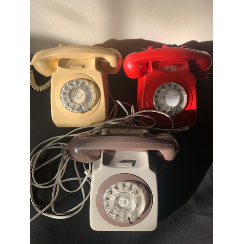 648 - Three vintage telephones, red, cream and brown.