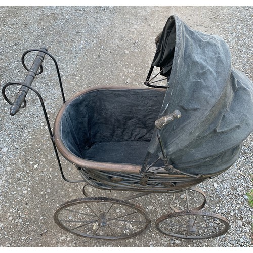 649 - A cane and metal dolls pram. 54 l x 35 w x 87cms l.