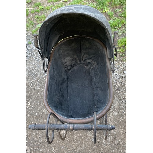 649 - A cane and metal dolls pram. 54 l x 35 w x 87cms l.