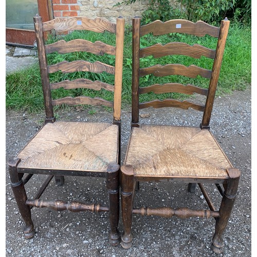 791 - Two oak ladder backed chairs with rush seats. 100cms h.