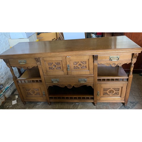 794 - An early 20thC oak Arts and Crafts sideboard. Three cupboards and three drawers with brass handles a... 