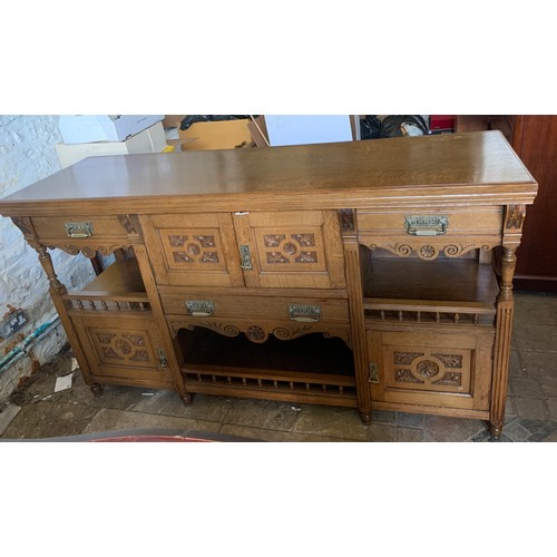 794 - An early 20thC oak Arts and Crafts sideboard. Three cupboards and three drawers with brass handles a... 