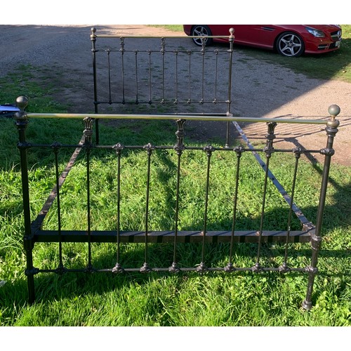 796 - A 19thC brass and iron double bedstead. 4'6'' wide with iron and wooden slats.