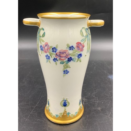 79 - A William Moorcroft for Macintyre Burslem vase with floral garlands and rosettes. 19cms.