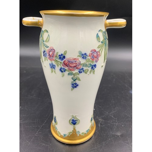 79 - A William Moorcroft for Macintyre Burslem vase with floral garlands and rosettes. 19cms.