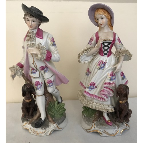 77a - A pair of Continental painted figurines of a man and woman both with dogs. 16cms h.