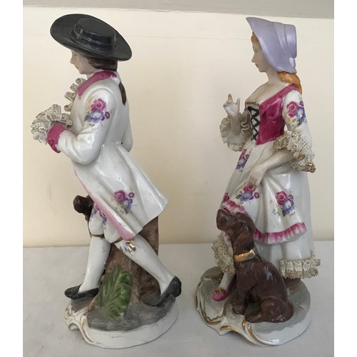 77a - A pair of Continental painted figurines of a man and woman both with dogs. 16cms h.