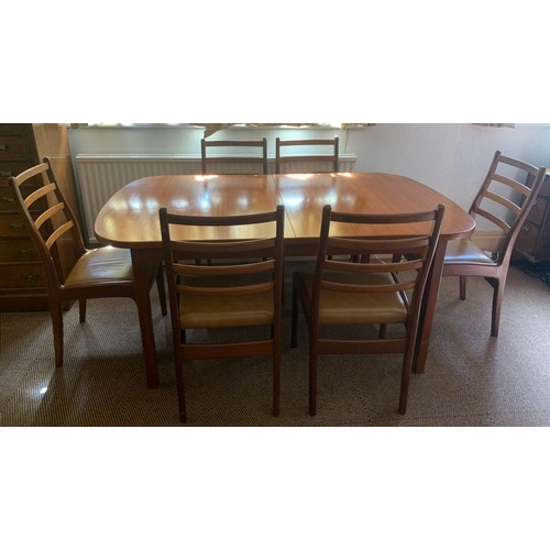 811A - An extending G Plan dining table and 6 chairs. 163 x 100cms closed, 254cms open.