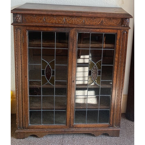 794A - An oak two door display cabinet with leaded glass doors. 113cms h x 92cms w x 33cms d.