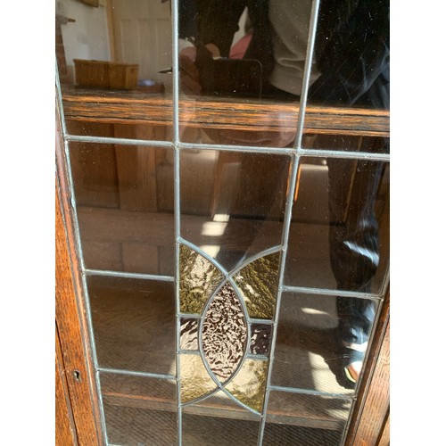 794A - An oak two door display cabinet with leaded glass doors. 113cms h x 92cms w x 33cms d.