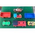Lot of wooden toys including two tractors, four trailers and a wooden cat puppet.