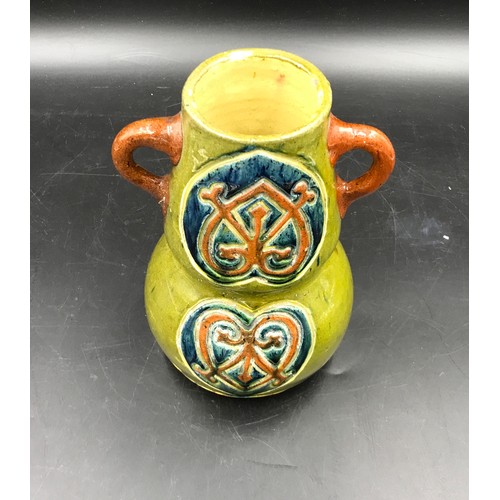 142 - A studio pottery stone ware vase with double handles and pattern to front and back. Art Nouveau styl... 