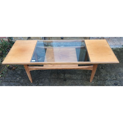 1233 - A G Plan teak coffee table with a central glass inlay panel, with undershelf. 137cms l x 51cms d x 4... 