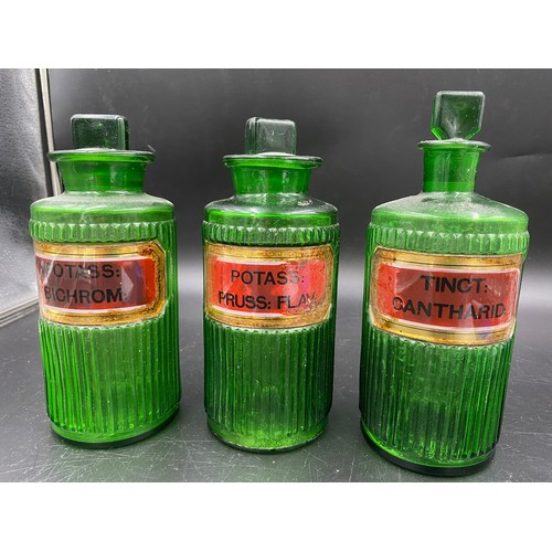 79 - A selection of eight late 19thC/early 20thC glass chemist jars  to include 3 ribbed green 19cms h, o... 