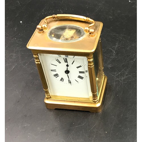 659 - A brass carriage clock with Swiss movement. 14cms h with handle up. Key included. Winds and goes. In... 