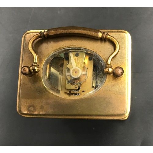 659 - A brass carriage clock with Swiss movement. 14cms h with handle up. Key included. Winds and goes. In... 