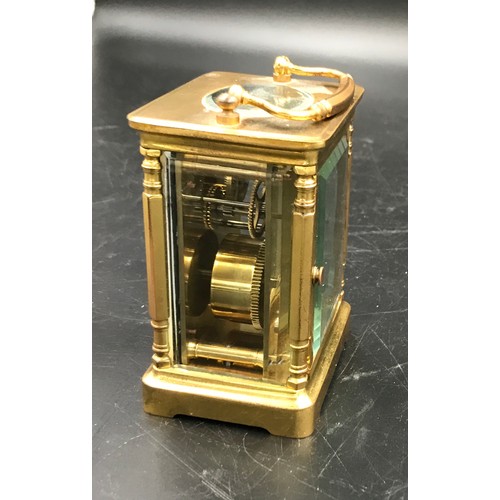 659 - A brass carriage clock with Swiss movement. 14cms h with handle up. Key included. Winds and goes. In... 