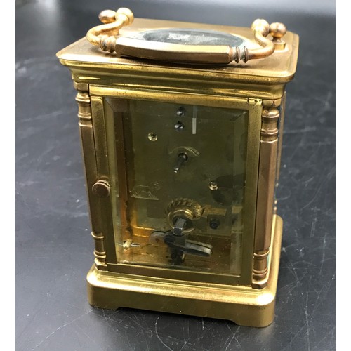 659 - A brass carriage clock with Swiss movement. 14cms h with handle up. Key included. Winds and goes. In... 