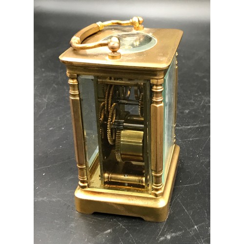 659 - A brass carriage clock with Swiss movement. 14cms h with handle up. Key included. Winds and goes. In... 