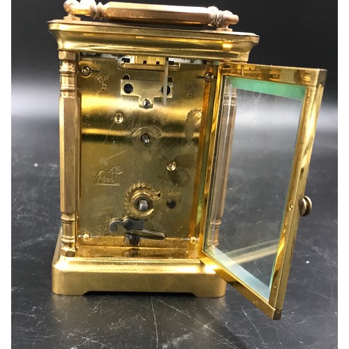 659 - A brass carriage clock with Swiss movement. 14cms h with handle up. Key included. Winds and goes. In... 