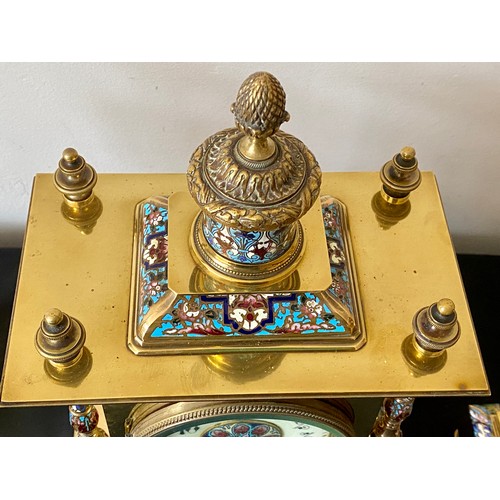 657 - A French brass and enamel clock garniture with enamelled pillars to each corner. 35cms h, candlestic... 