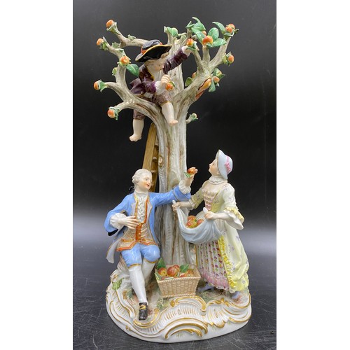 69 - A Meissen figurine group of apple pickers depicting a boy in a tree picking apples, a lady and gent ... 