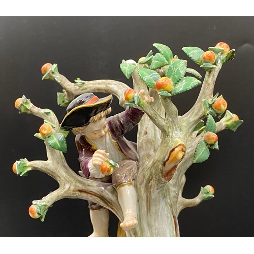 69 - A Meissen figurine group of apple pickers depicting a boy in a tree picking apples, a lady and gent ... 