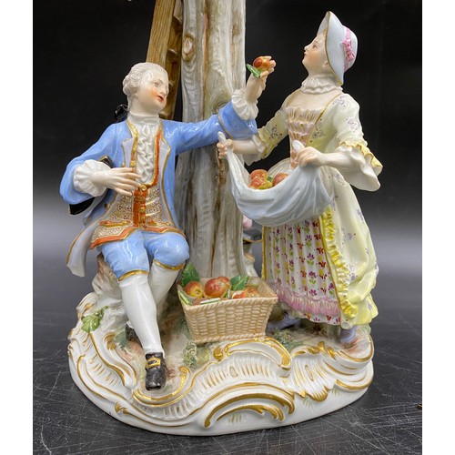 69 - A Meissen figurine group of apple pickers depicting a boy in a tree picking apples, a lady and gent ... 