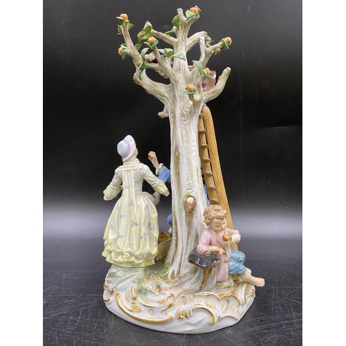 69 - A Meissen figurine group of apple pickers depicting a boy in a tree picking apples, a lady and gent ... 