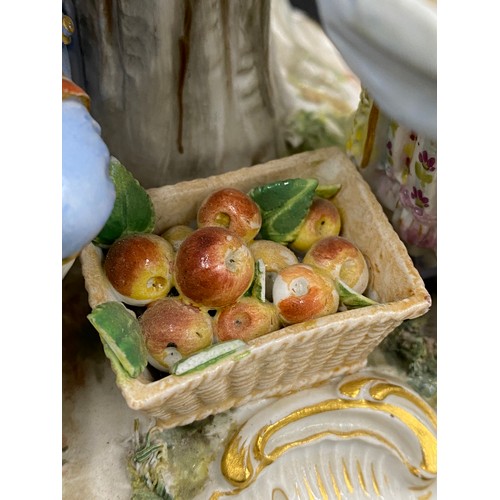 69 - A Meissen figurine group of apple pickers depicting a boy in a tree picking apples, a lady and gent ... 