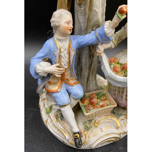 69 - A Meissen figurine group of apple pickers depicting a boy in a tree picking apples, a lady and gent ... 