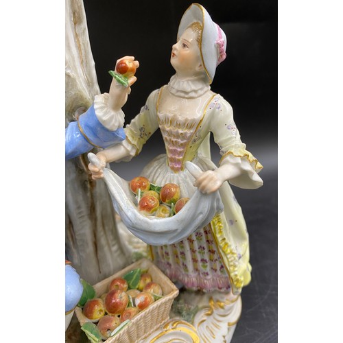 69 - A Meissen figurine group of apple pickers depicting a boy in a tree picking apples, a lady and gent ... 