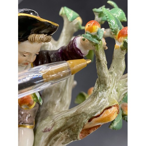 69 - A Meissen figurine group of apple pickers depicting a boy in a tree picking apples, a lady and gent ... 