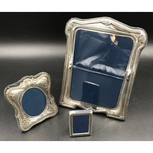 541 - Three hallmarked silver photo frames. Largest Sheffield 1996 24cms h x 18cms w, floral embossed stam... 