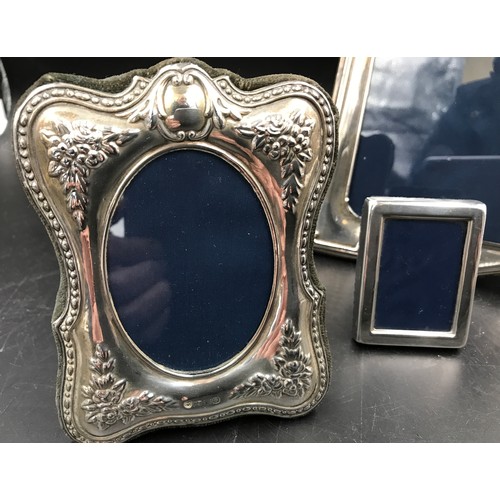 541 - Three hallmarked silver photo frames. Largest Sheffield 1996 24cms h x 18cms w, floral embossed stam... 