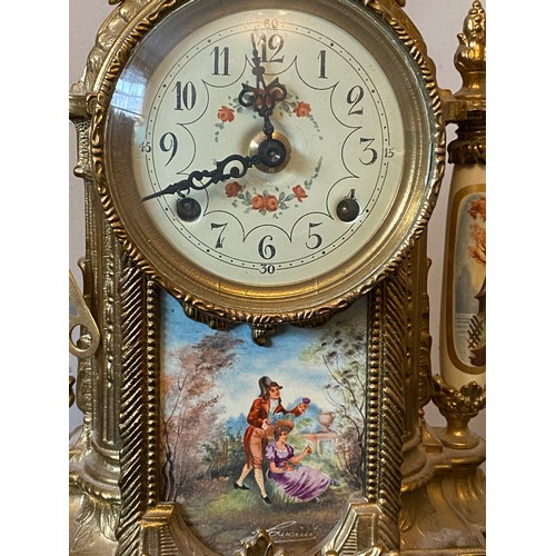 660 - A 20thC decorative French brass and ceramic clock garniture. Clock 42cms h, vase 33cms h.