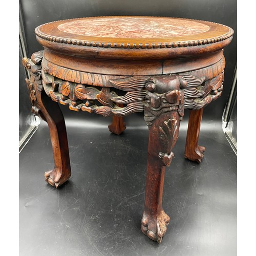 1217 - A Chinese carved hardwood stand with a circular top and marble inlay. 46cms h x 46cms w.