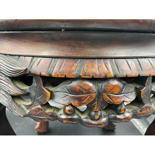 1217 - A Chinese carved hardwood stand with a circular top and marble inlay. 46cms h x 46cms w.