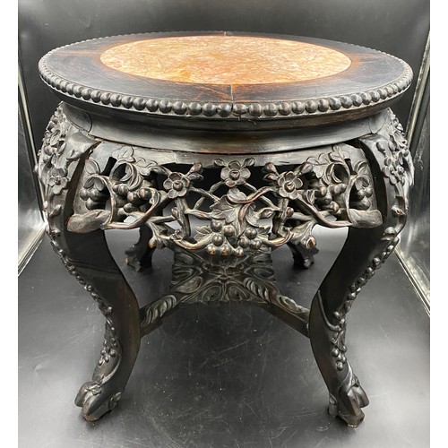 1218 - A Chinese carved hardwood circular stand with marble inlay and floral carving.