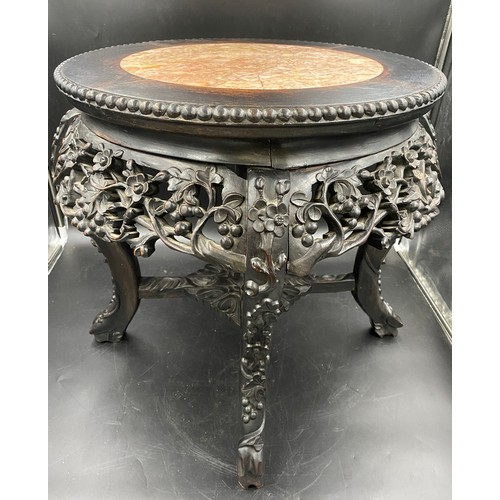 1218 - A Chinese carved hardwood circular stand with marble inlay and floral carving.