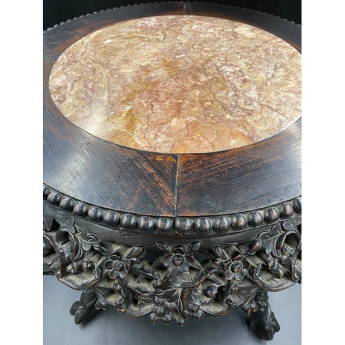 1218 - A Chinese carved hardwood circular stand with marble inlay and floral carving.