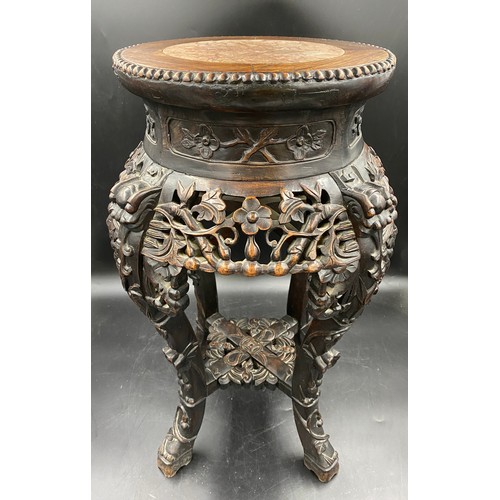 1219 - A Chinese carved hardwood stand with floral carving and marble inlay to the top. Width at feet 37cms... 