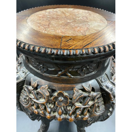 1219 - A Chinese carved hardwood stand with floral carving and marble inlay to the top. Width at feet 37cms... 