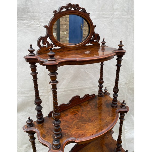 1220 - A Victorian walnut four tier graduating what-not with oval mirror and string inlay. On castors. 76cm... 