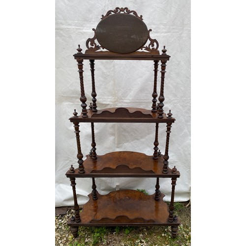 1220 - A Victorian walnut four tier graduating what-not with oval mirror and string inlay. On castors. 76cm... 