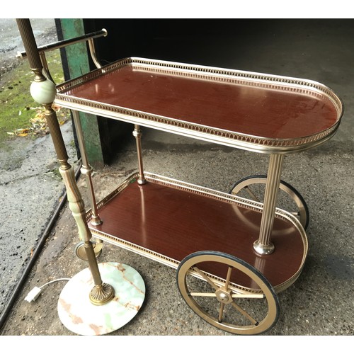 555 - Onyx and brass standard lamp 148cms h and a brass effect two tier serving tea trolley.