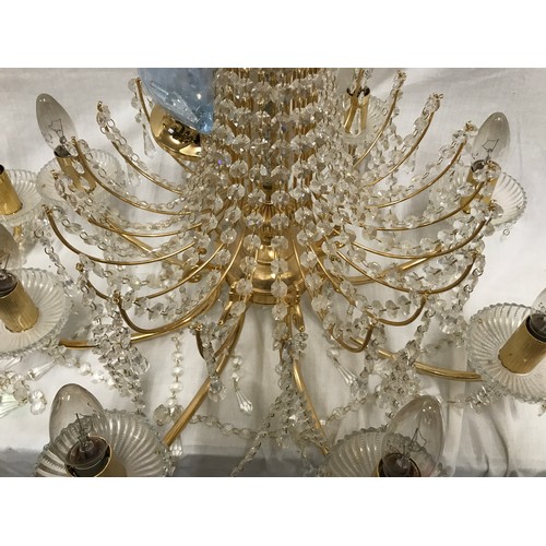 549 - Two glass droplet and brass ceiling light chandeliers. Largest 8 branch approx. 60cms w, height to c... 