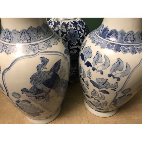 1267 - Pair of Chinese blue and white vases, 47cms h and a blue and white vase with lid 38cms h.