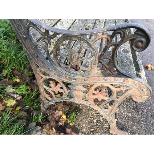 1326 - A cast iron garden bench with lion head design panels, 148cms w x 60cms d x 85cms h.